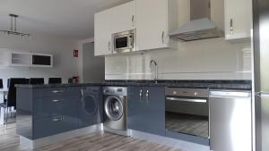 a kitchen with blue cabinets and a washer and dryer at Canadina 2 in Morgovejo