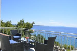 einen Balkon mit Stühlen, einem Tisch und Meerblick in der Unterkunft Apartments Marija in Ivan Dolac