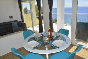 a dining table and chairs with a view of the ocean at Apartments Marija in Ivan Dolac