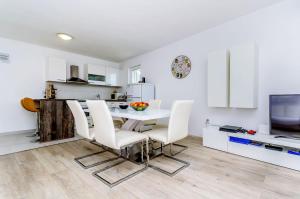 a kitchen and dining room with a table and chairs at House Ivana in Vinišće