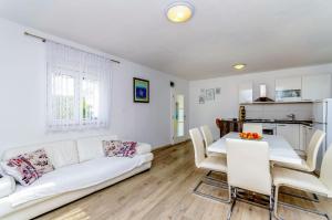 a living room with a white couch and a table at House Ivana in Vinišće