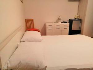 a bedroom with a white bed and a chair at Apartment and Rooms Ruza in Trogir +14 photos