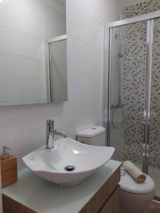 a white bathroom with a sink and a toilet at Casa da Cuca in Campo do Gerês