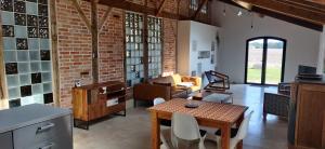 salon ze ścianą z cegły i stołem w obiekcie La Grange d'Hardy w mieście Soustons