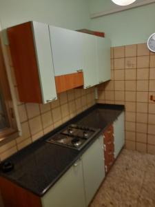 a small kitchen with a stove and white cabinets at numero uno in Lido di Jesolo