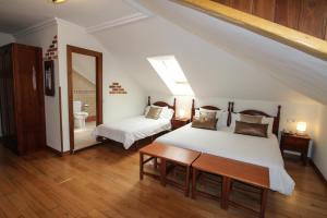 a bedroom with two beds and a table and a mirror at Hotel Rural El Espino in Cangas de Onís