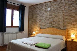 拉斯馬哈達斯的住宿－Casa Rural Javier El Molino，一间卧室配有一张带绿毛巾的床
