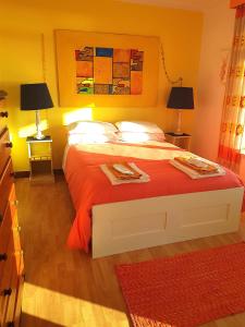 a bedroom with a large bed with red sheets at Casa Branca Guest House in Foz do Arelho