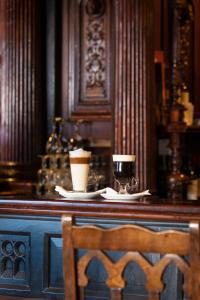 a bar with two cups of coffee and a chair at Treacy’s Hotel Spa & Leisure Club Waterford in Waterford