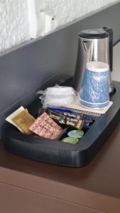 a table with a tray with books and a vase at Kyriad Angoulême Nord Champniers- Hôtel & Résidence in Champniers