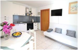 eine Küche und ein Wohnzimmer mit einem Sofa und einem Tisch in der Unterkunft Apartments Elvis in Primošten