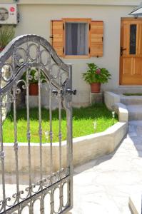 una puerta metálica frente a un patio con césped en Apartman Romana en Trogir
