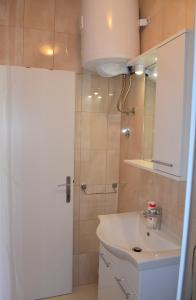 y baño con lavabo blanco y ducha. en Apartman Romana en Trogir