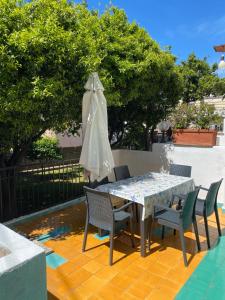 a table and chairs with an umbrella on a patio at Appartamento in villa in Forio d'Ischia