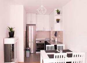 Una cocina con gabinetes blancos y un refrigerador de acero inoxidable. en Apartment Helena, en Trebinje