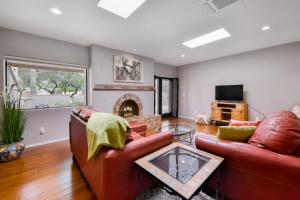 a living room with a leather couch and a fireplace at Colonia Verde in Tucson