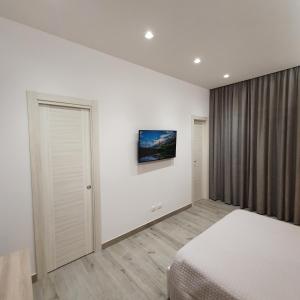 1 dormitorio con 1 cama y TV en la pared en Appartamento la Perla - vicino al mare, en Anzio