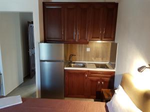 Una cocina con refrigerador de acero inoxidable y gabinetes de madera. en Itamos Migdanis House, en Vourvourou 35 fotos más