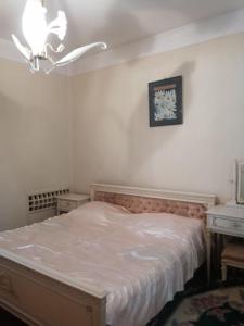 um quarto com uma cama, um candeeiro e uma mesa em Apartment on Rustaveli 41 em Batumi