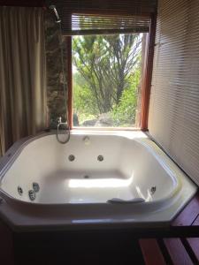 a bath tub in a bathroom with a window at Cabaña julian in La Cumbrecita