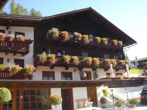 um edifício com vasos de plantas nas varandas em Ferienhof Oberer Gollmitzer em Heiligenblut
