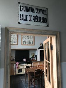 a kitchen with a table and a sign above a door at B&B Le flaneur in Bruges