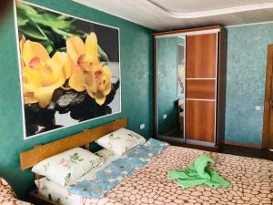 ヴォロネジにあるGuesthouse Berezovskayaのベッドルーム1室(壁に花を飾ったベッド1台付)