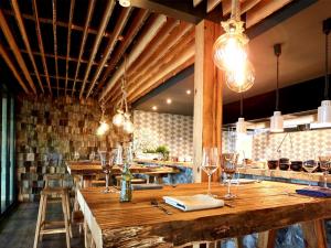 a restaurant with a long wooden table with wine glasses at Blockhaus im Ferienhauspark Asgard in Damp +17 photos
