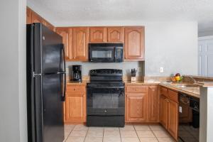 拉斯維加斯的住宿－Club Wyndham Grand Desert，厨房配有黑色冰箱和木制橱柜。