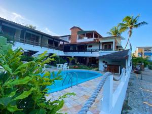 a house with a swimming pool in front of it at Pousada Luz do Porto in Porto De Galinhas