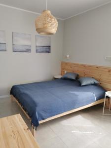 1 dormitorio con 1 cama grande con manta azul en Willa Medom, en Władysławowo
