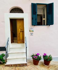 a house with a door and two pots of flowers at La casa di Nonna Clo, nel centro di Vasto in Vasto