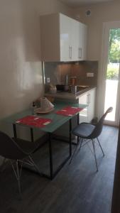 - une cuisine avec une table verte et 2 chaises dans l'établissement Les Floralies bis, à Pau