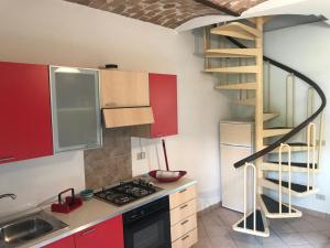 a kitchen with red cabinets and a spiral staircase at Val Giardino 2 Casa Vacanze in Roccamorice