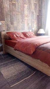 ein Bett mit einem Holzrahmen in einem Schlafzimmer in der Unterkunft Les Floralies bis in Pau