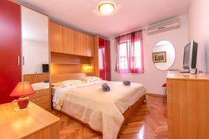 a bedroom with a large bed and a television at Apartment Ursus in Split