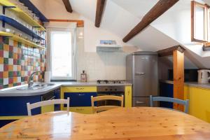 a kitchen with a wooden table and yellow cabinets at Apartment Lira in Split