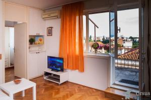 a living room with a television and a large window at Apartment Janjiš in Split