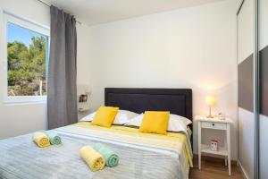 um quarto com uma cama com almofadas amarelas e uma janela em Olive Eden Holiday Home em Milna