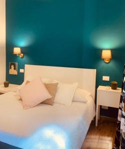 a bedroom with a white bed with a blue wall at casetta di Vernazza in Vernazza