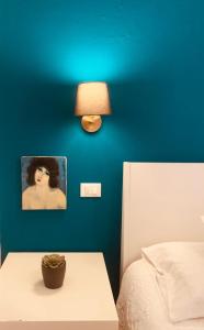 a bedroom with a blue wall and a table with a lamp at casetta di Vernazza in Vernazza