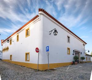 a white building with a street sign in front of it at ADC - Albergaria Do Calvário - by Unlock Hotels in Évora +48 photos
