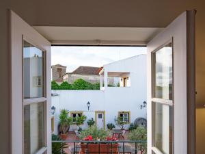 un balcón abierto con vistas a una casa en ADC - Albergaria Do Calvário - by Unlock Hotels en Évora