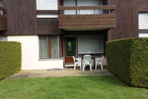 a patio with chairs and a table in front of a house at Appart en rez de jardin clos face au Mont BLANC in Combloux
