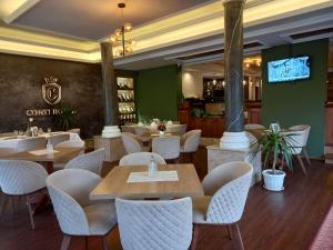 a restaurant with tables and chairs and a tv at Conti Hotel & Restaurant in Gjakove