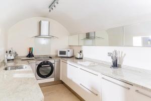 Una cocina con gabinetes blancos y lavavajillas. en 16 Lansdown -By Luxury Apartments, en Cheltenham