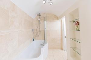 y baño con bañera blanca y ducha. en 16 Lansdown -By Luxury Apartments, en Cheltenham 14 fotos más