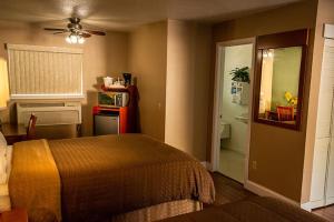 a bedroom with a bed and a door to a bathroom at Maple Leaf Motel in Shady Cove