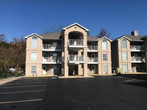 a large apartment building with a parking lot at Lakeside Condo on Lake Taneycomo in Branson