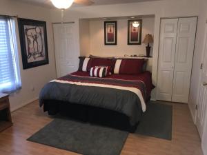a bedroom with a bed with red and white pillows at Lakeside Condo on Lake Taneycomo in Branson